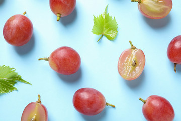 Flat lay composition with fresh ripe juicy grapes on light blue background