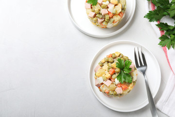 Flat lay composition with traditional salad Olivier on light table, space for text