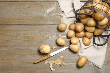 Raw fresh organic potatoes on wooden background, flat lay. Space for text