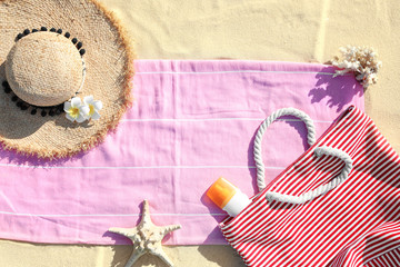 Flat lay composition with different beach accessories on sand