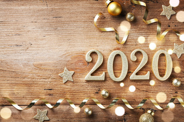 New Year celebration and festive background with golden numbers 2020, confetti stars and Christmas decorations top view.