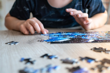 boy raises a small puzzle. childhood development