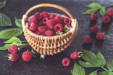 fresh raspberry. raspberry harvest in a wicker basket on a wooden background. background with raspberry close-up.