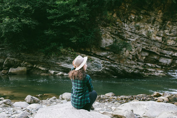 Woman raised hands enjoying landscape  in mountains  Young girl in a hat