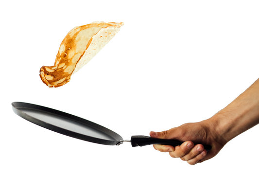 Frying pan with flying pancake isolated on white background