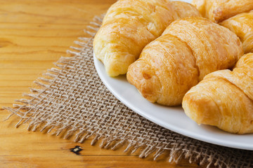 Closeup croissant  on wooden table. breakfast concept.