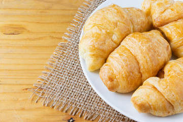 Closeup croissant  on wooden table. breakfast concept.