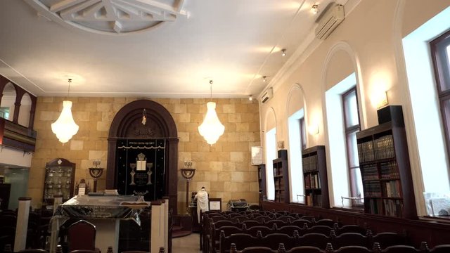 Classical interior of the Synagogue: shell rock wall, chairs, bookshelves and religious artifacts. Historic building of the Jewish community. Traditional house of Jewish Spirituality and Divine Law.