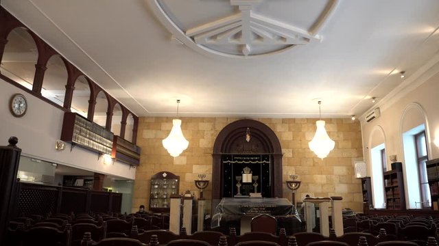 Classical interior of the Synagogue: shell rock wall, chairs, bookshelves and religious artifacts. Historic building of the Jewish community. Traditional house of Jewish Spirituality and Divine Law.