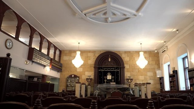 Classical interior of the Synagogue: shell rock wall, chairs, bookshelves and religious artifacts. Historic building of the Jewish community. Traditional house of Jewish Spirituality and Divine Law.