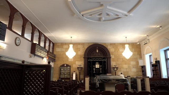 Classical interior of the Synagogue: shell rock wall, chairs, bookshelves and religious artifacts. Historic building of the Jewish community. Traditional house of Jewish Spirituality and Divine Law.