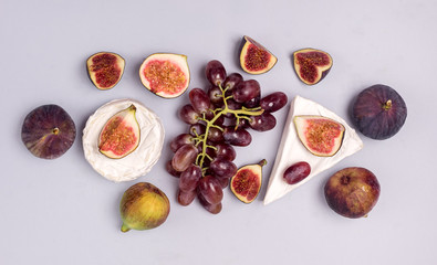 Brie Cheese Ripe Cut Figs Ripe Grape are Lying on Blue Background Food Background with Cheese and AutumnFruits Copy Space Horizontal Flat Lay
