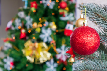 Christmas tree decorated with Red balls toys on a white wall, copy space.