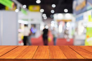 Wood table top on blur exhibition show background. for montage and display products