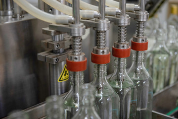 close up machines filling fresh water to glass bottles