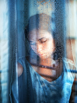 Close up of young woman standing by window