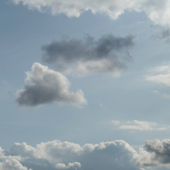 One dark cloud is rising behind the cloud nine. The two clouds in the middle are surrounded with a natural cloudy frame.
