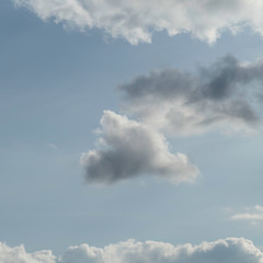 One floating cloud surrounded by other clouds with copy space in the blue air.