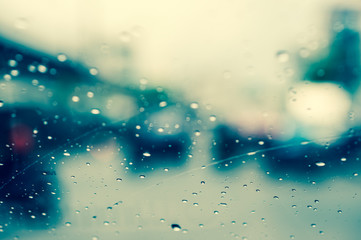 Abstract rain drop on windows and blur traffic jam background