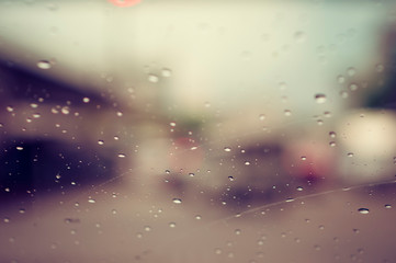 Abstract rain drop on windows and blur traffic jam background