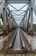 Fototapeta na wymiar Turn of the century old steel railway bridge over the Vah river in Slovakia