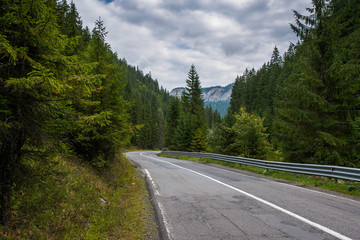 Asphalt road leading to the mountain , storm clouds in Transylvania, Romania.