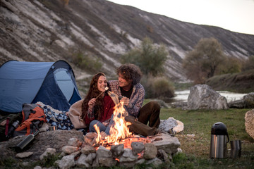 Fototapeta premium A young couple is on fire, the boy warms his friend