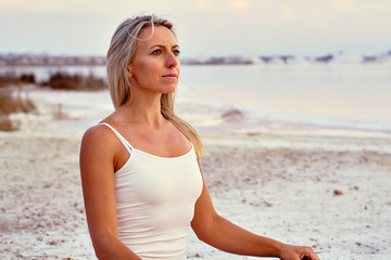 Fototapeta na wymiar Middle aged 50s yogi woman meditating on nature