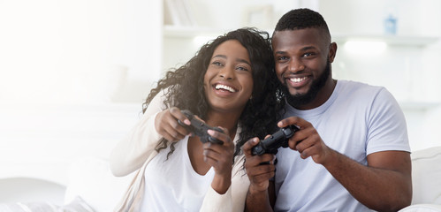 Playful millennial couple competing with each other in video game © Prostock-studio