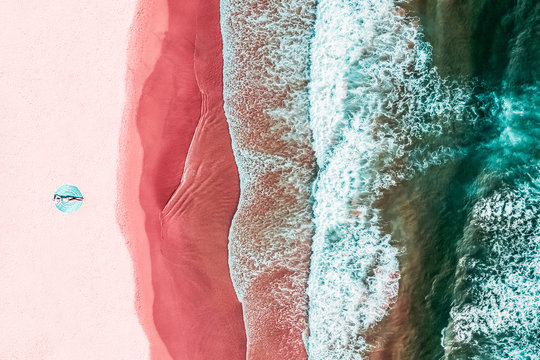 Aerial View Of Woman On Pink Ocean Beach