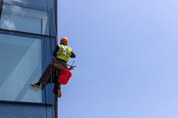 Fototapeta premium Window cleaner on high-rise buildings. Industrial climber.