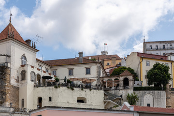 Obraz premium Restaurant with balcony below University of Coimbra on hilltop above the city from Santa Clara bridge