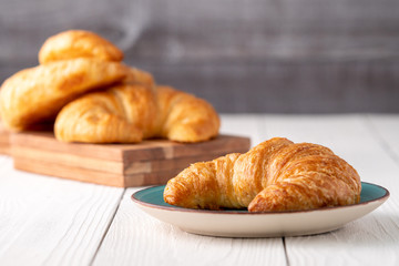 Flacky crispy fresh croissant rolls with blue background