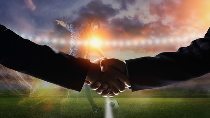 Image handshake with soccer field background.Business with football games