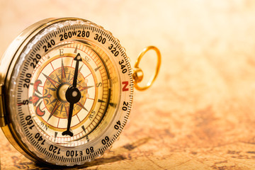 Vintage compass on global map close up.