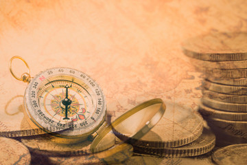Double exposure vintage compass on money piles coin