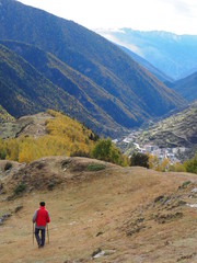 Naklejka premium Man walking alone on the top of the scenic mountain with beautiful Rilong city view in China in autumn. Trekking holiday solo travel and inspirational concept