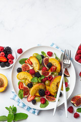 Summer fruit and berry salad with chia seeds on white plate