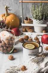autumn cosy pumpkin, candles and autumn plants on window with led lights bokeh