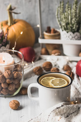 autumn cosy pumpkin, candles and autumn plants on window with led lights bokeh