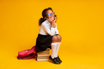 Smiling First Grader Girl Sitting On Book Stack In Studio