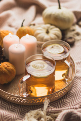 autumn cosy pumpkin, candles and autumn plants on window with led lights bokeh