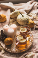 autumn cosy pumpkin, candles and autumn plants on window with led lights bokeh