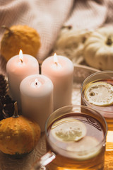 Obraz na płótnie Canvas autumn cosy pumpkin, candles and autumn plants on window with led lights bokeh