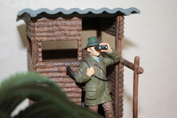 toy huntsman looking through binoculars