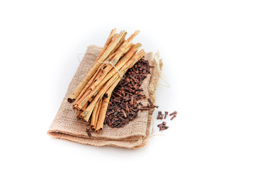 cloves and cinnamon on burlap sacks isolated white