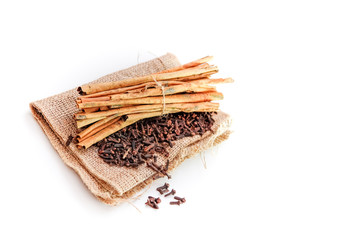 cloves and cinnamon on burlap sacks isolated white