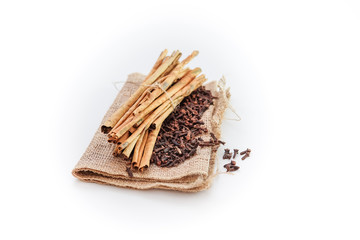 cloves and cinnamon on burlap sacks isolated white