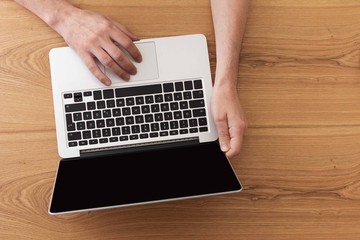Man working on laptop, top view on male hands using laptop