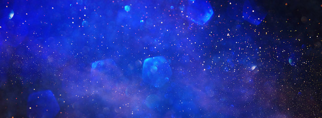 background of abstract glitter lights. blue and black. de focused. banner